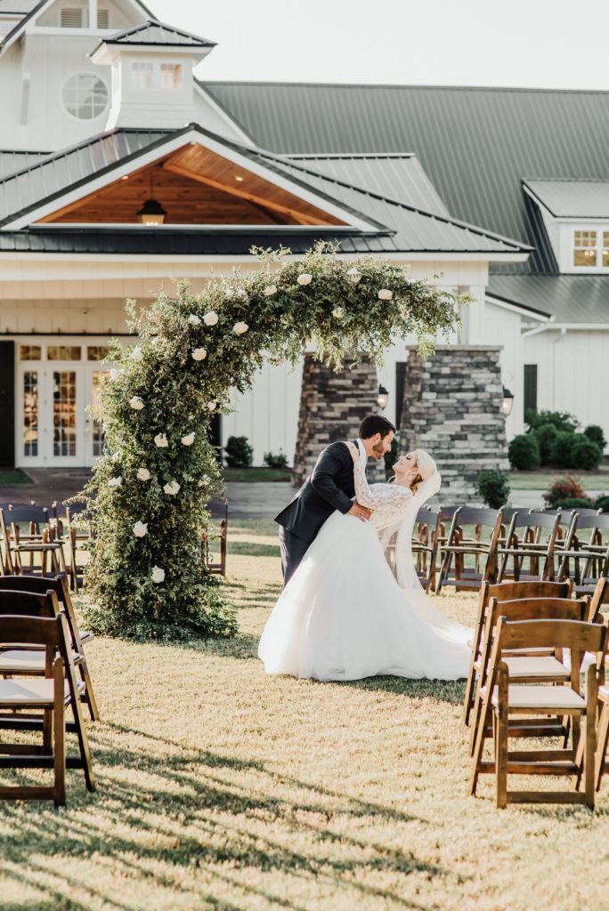 Ceremony backdrop with greenery and white flowers at the Carolina Barn at McCormick Farms, classic, modern, sophisticated barn inspiration