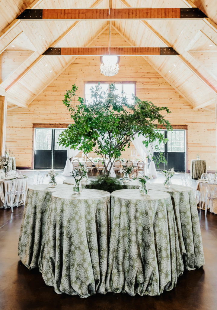 Cocktail linen with green patterned linen.  Green & white linen. Tree centered in cocktail tables.  The Carolina Barn at McCormick Farms.  