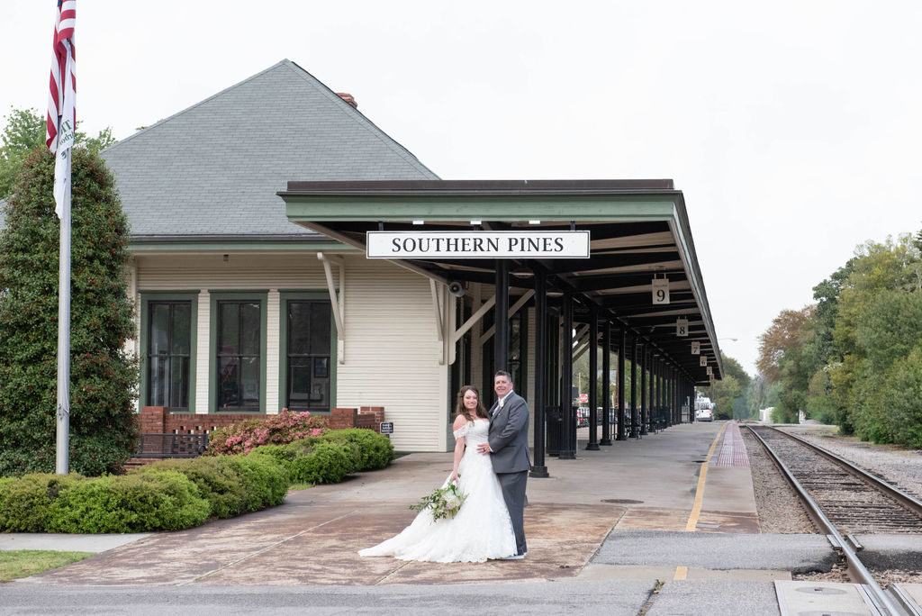 bride and groom in front of train station